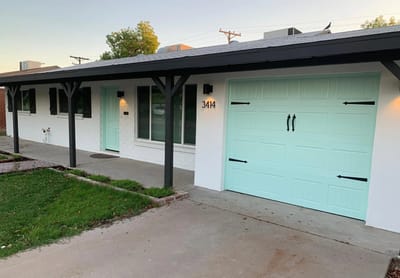 Exterior view of a residential building with a mint green garage door