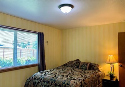 Cozy private room with floral bedding and lamp