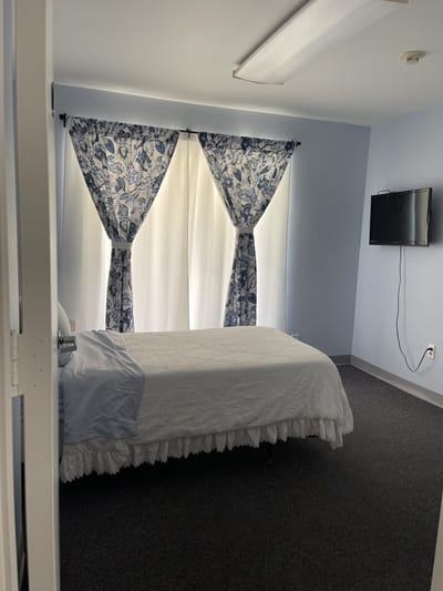 A bright, cozy private resident room with curtains