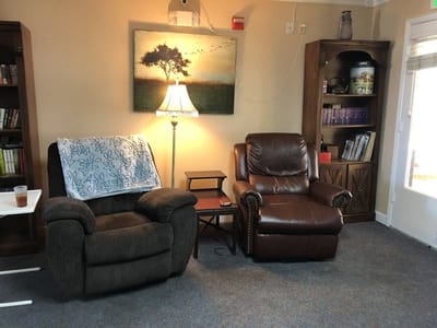 Cozy sitting area with a lamp and bookshelves