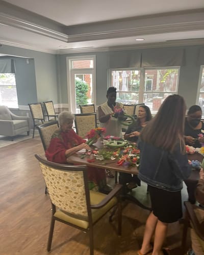Residents and staff engaging in a flower arranging activity