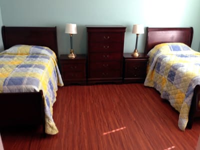 A shared resident room with two beds and lamps