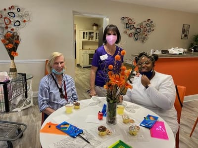 Residents and staff enjoying a decorating activity with snacks