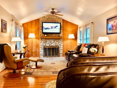 Cozy lounge area with seating, fireplace, and TV