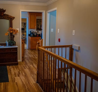 Interior hallway with wooden railing and cabinets