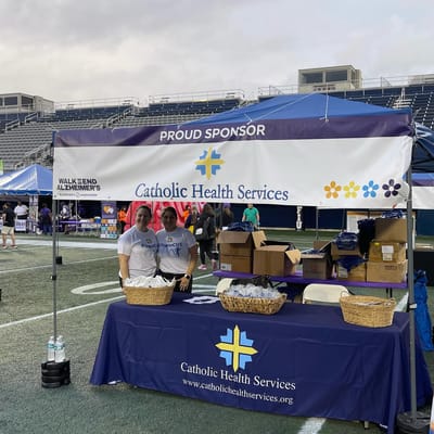 Two staff members at a sponsorship booth for Alzheimer's walk