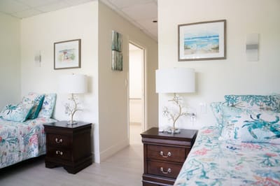 Twin bedroom with floral bedding and decorative lamps
