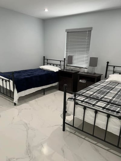 A well-furnished room with two beds and a nightstand