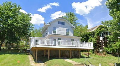 Exterior view of a white house with a deck