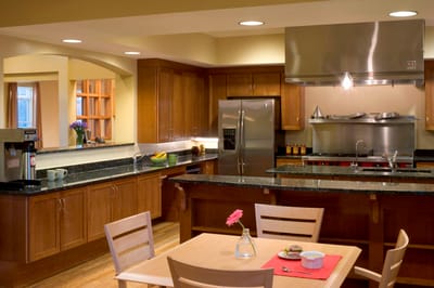 Modern kitchen area with wooden cabinets and stainless steel appliances
