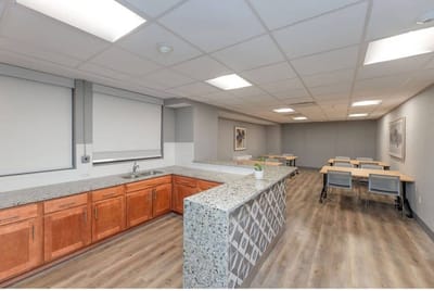 Bright common area with tables and kitchenette