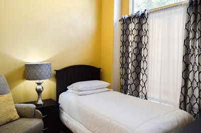 Cozy resident room with yellow walls and a single bed