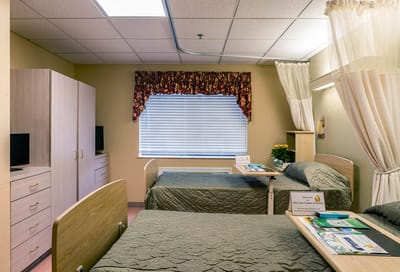 Private resident room with two beds and natural light