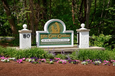 Entrance sign of Life Care Center with flowers
