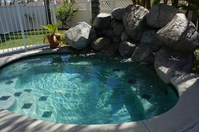 Hot tub surrounded by rocks and greenery
