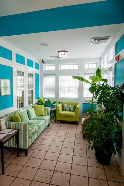 Bright common area with green furniture and plants