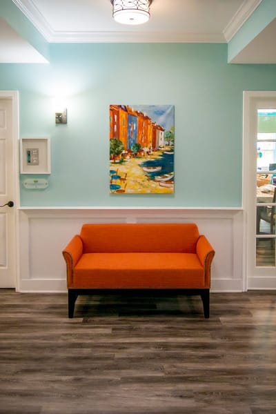 Bright interior with orange sofa and colorful artwork