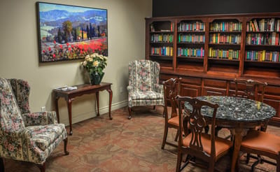 Cozy common area with floral armchairs and bookshelf