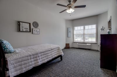 Bright private resident room with a bed and decor