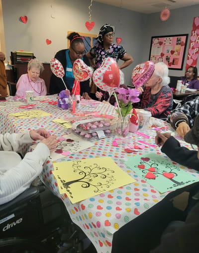 Residents and staff celebrating an event at a decorated table