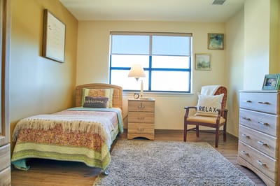 Cozy interior of a resident room with a bed and chair