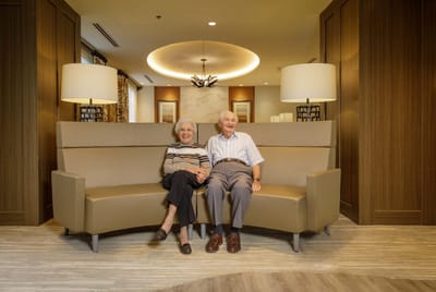 Two residents sitting together in a cozy lounge area