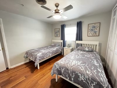 Two twin beds in a well-lit room.