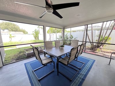 Screened porch with a dining table and chairs