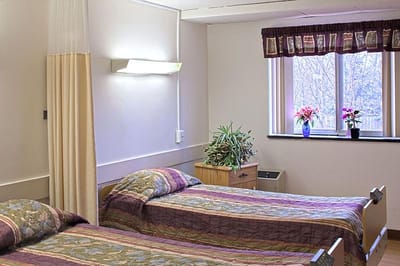 A cozy resident room with two beds and a view