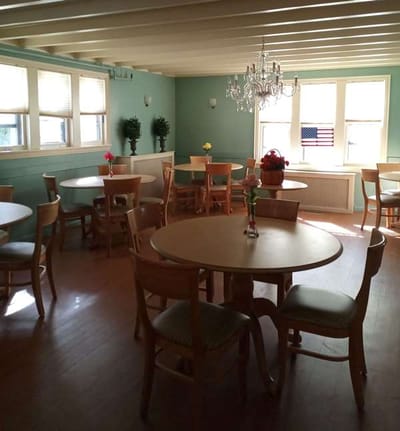 Common area with tables and chairs in a well-lit room