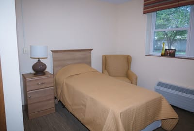 Cozy resident room with a bed and chair