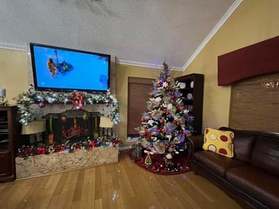 Decorated common area with a Christmas tree and television