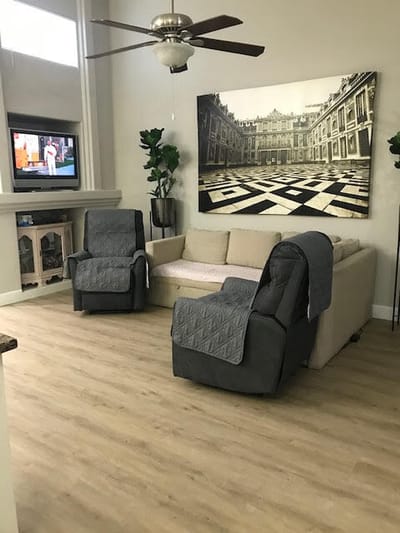 A cozy lounge area with recliners and a large artwork