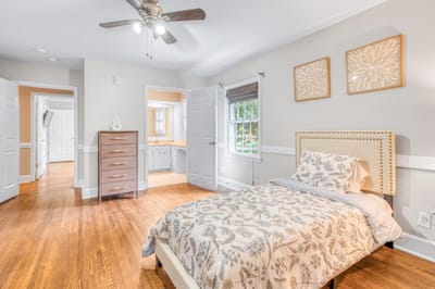 Cozy resident room with floral bedding and hardwood floors