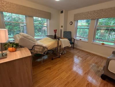 A private resident room with a bed and windows