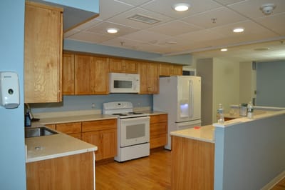 Bright kitchen area with wooden cabinets and appliances