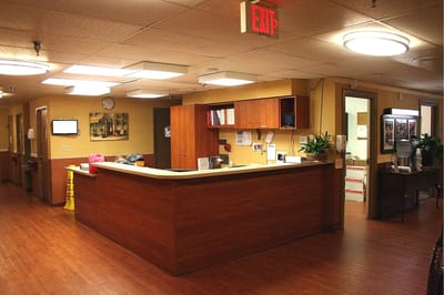 Reception area with wooden front desk and seating