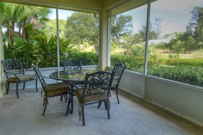 Outdoor seating area with chairs and a table in a sunroom