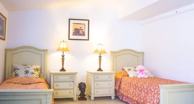 Brightly lit shared bedroom with twin beds and decor