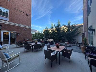 Outdoor seating area with tables and greenery