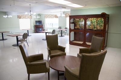 Common area with seating and tables in a senior care facility