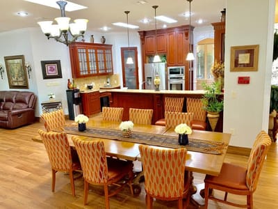 Bright dining area with a large table and kitchen
