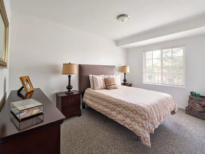 Cozy interior of a private resident room with a bed and dresser