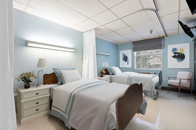 A shared room with two beds and light blue walls