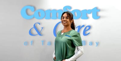 Staff member with logo backdrop in facility interior