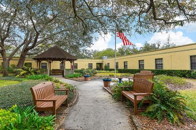 Outdoor pathway with benches and gazebo in a senior living community