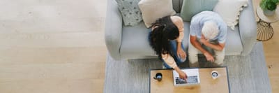 Two residents using a laptop in a cozy living room
