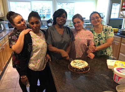 Staff members celebrating with a cake in the kitchen