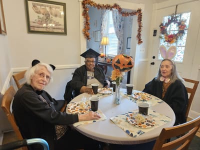 Three residents celebrating at a decorated table