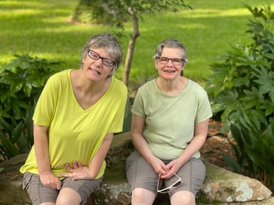 Two smiling residents sitting outdoors